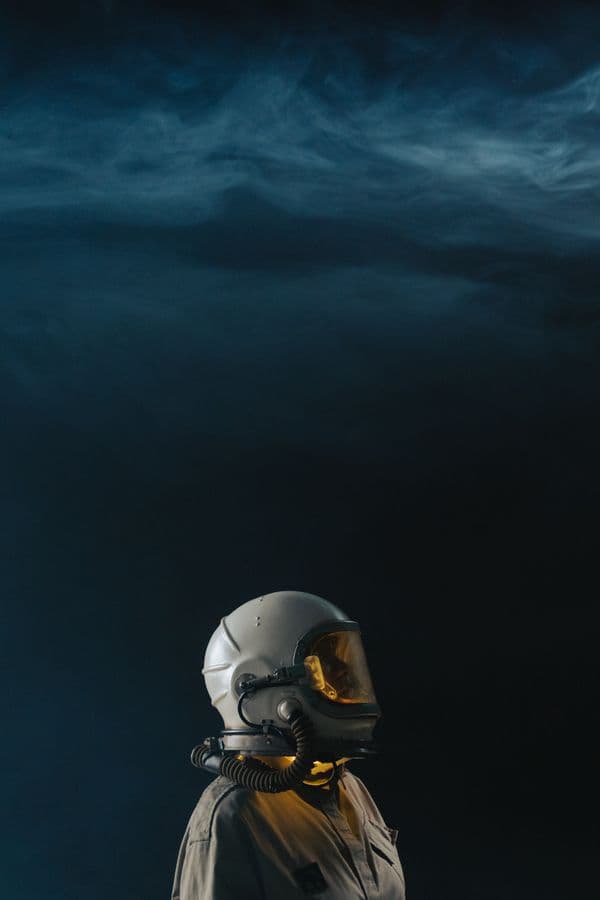 Astronaut helmet glowing under drifting smoke