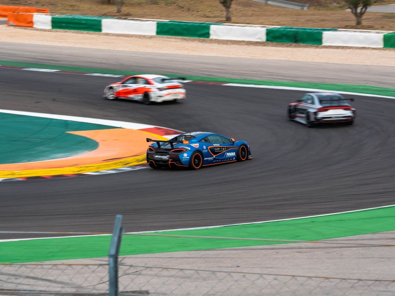 Race cars cornering on a circuit